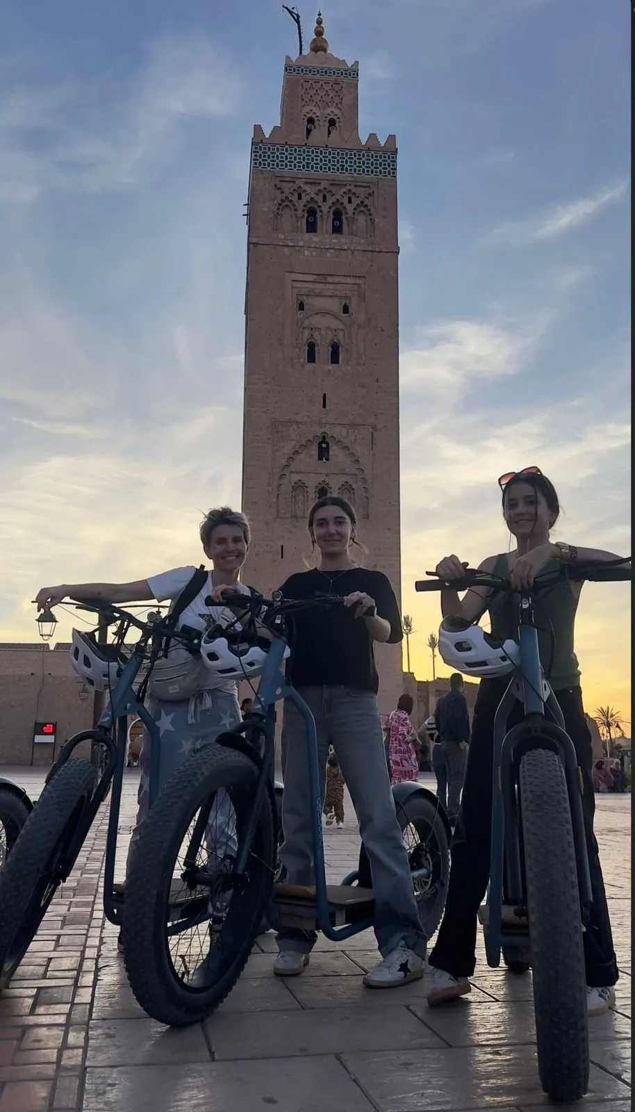 Trois participantes devant la Koutoubia au coucher du soleil