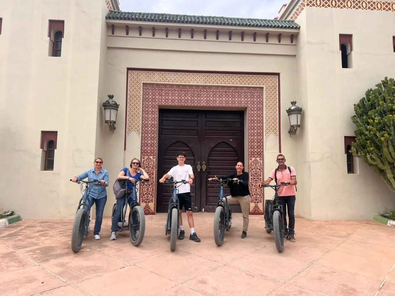 Groupe en trottinette devant une porte marocaine traditionnelle