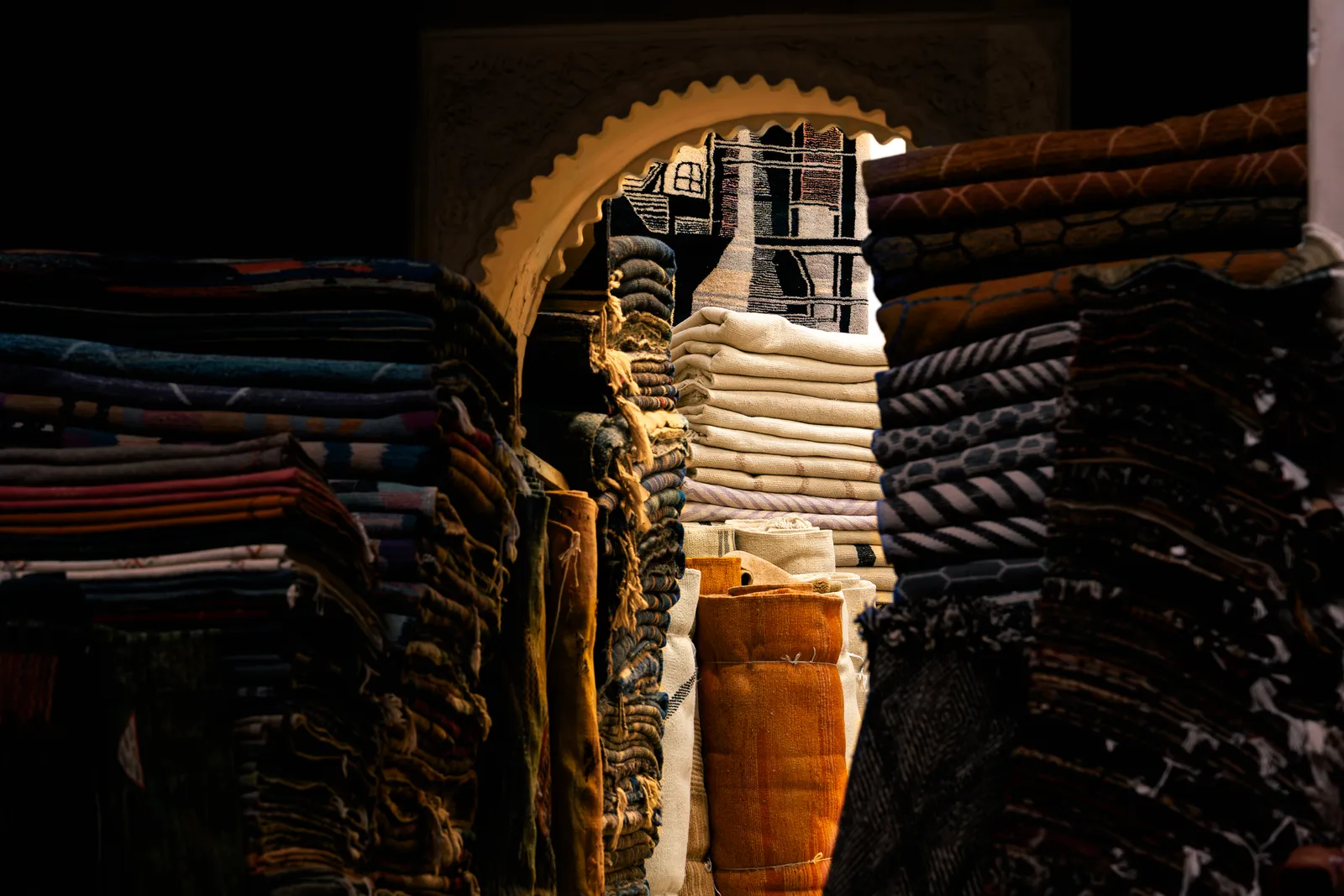 Piles de tapis sous une arche sculptée